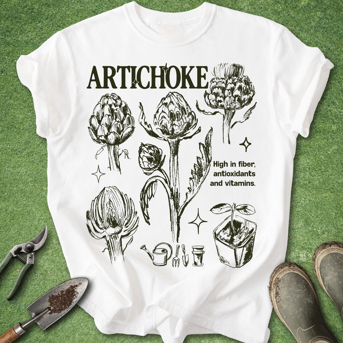 White Comfort Colors t-shirt featuring vintage botanical illustrations of artichokes in different growth stages with gardening icons and educational text in a natural history inspired design.