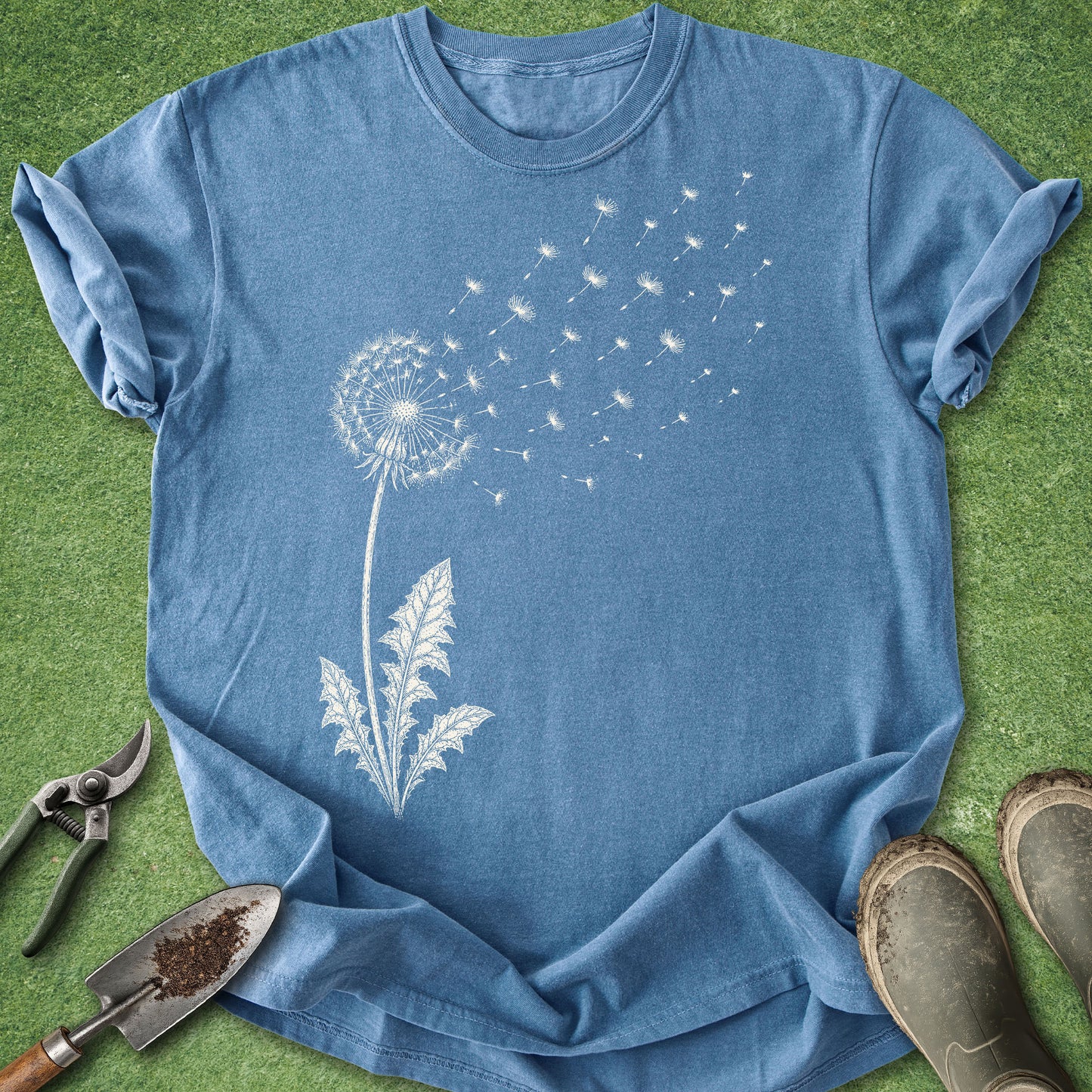 Blue t-shirt with a dandelion graphic on a green grass background