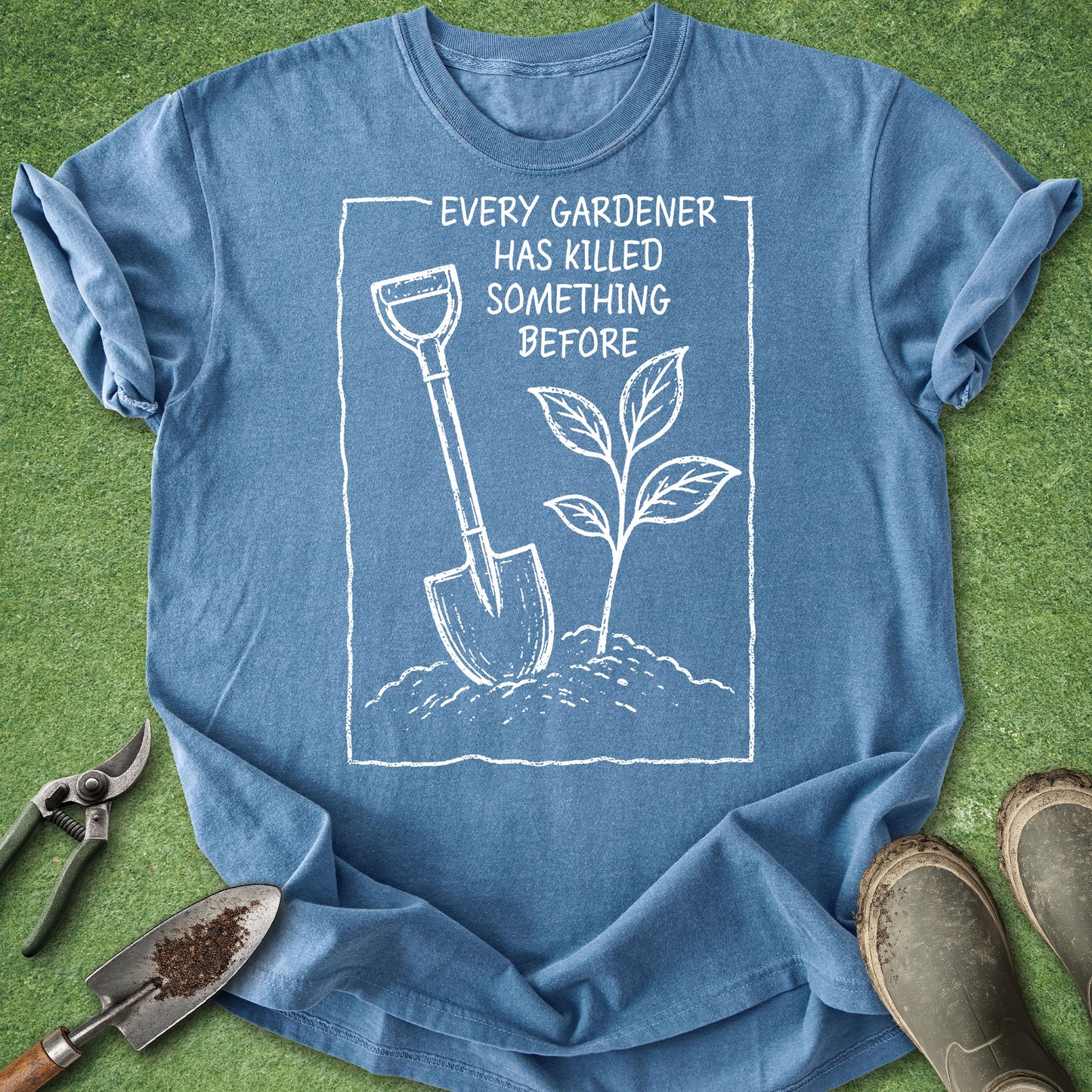 Blue t-shirt with gardening graphic and text on a grass background