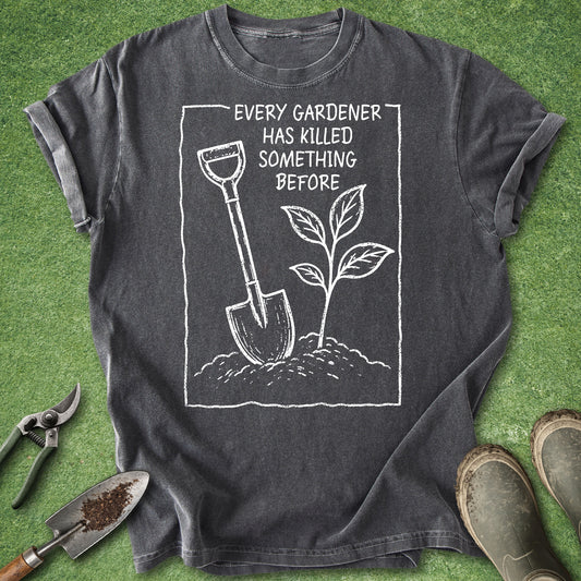 Pepper Comfort Colors t-shirt featuring the phrase "Every Gardener Has Killed Something Before" with a hand-drawn shovel and young seedling growing from soil in a minimalist gardening illustration.