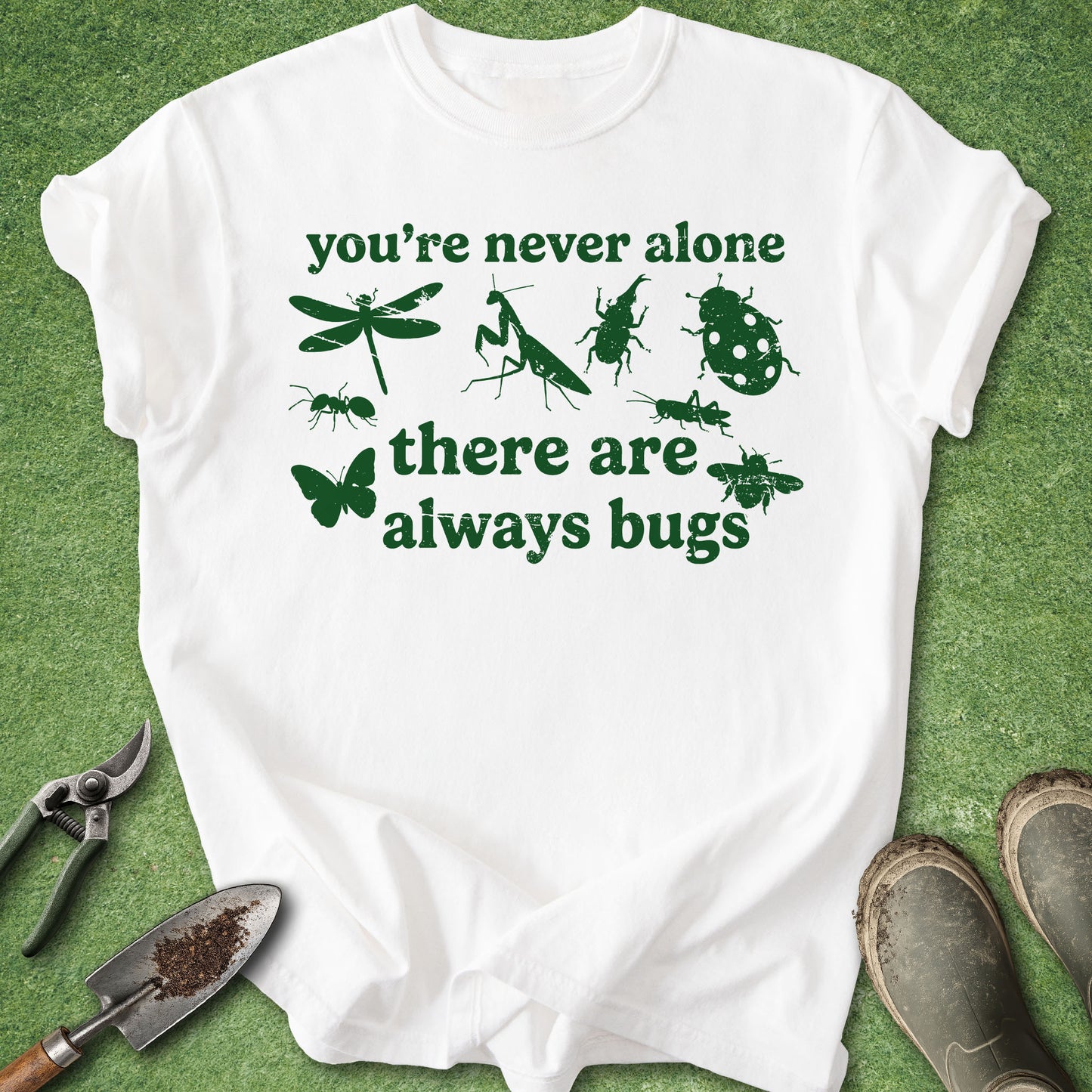 White t-shirt with green text and insect illustrations on a grass background