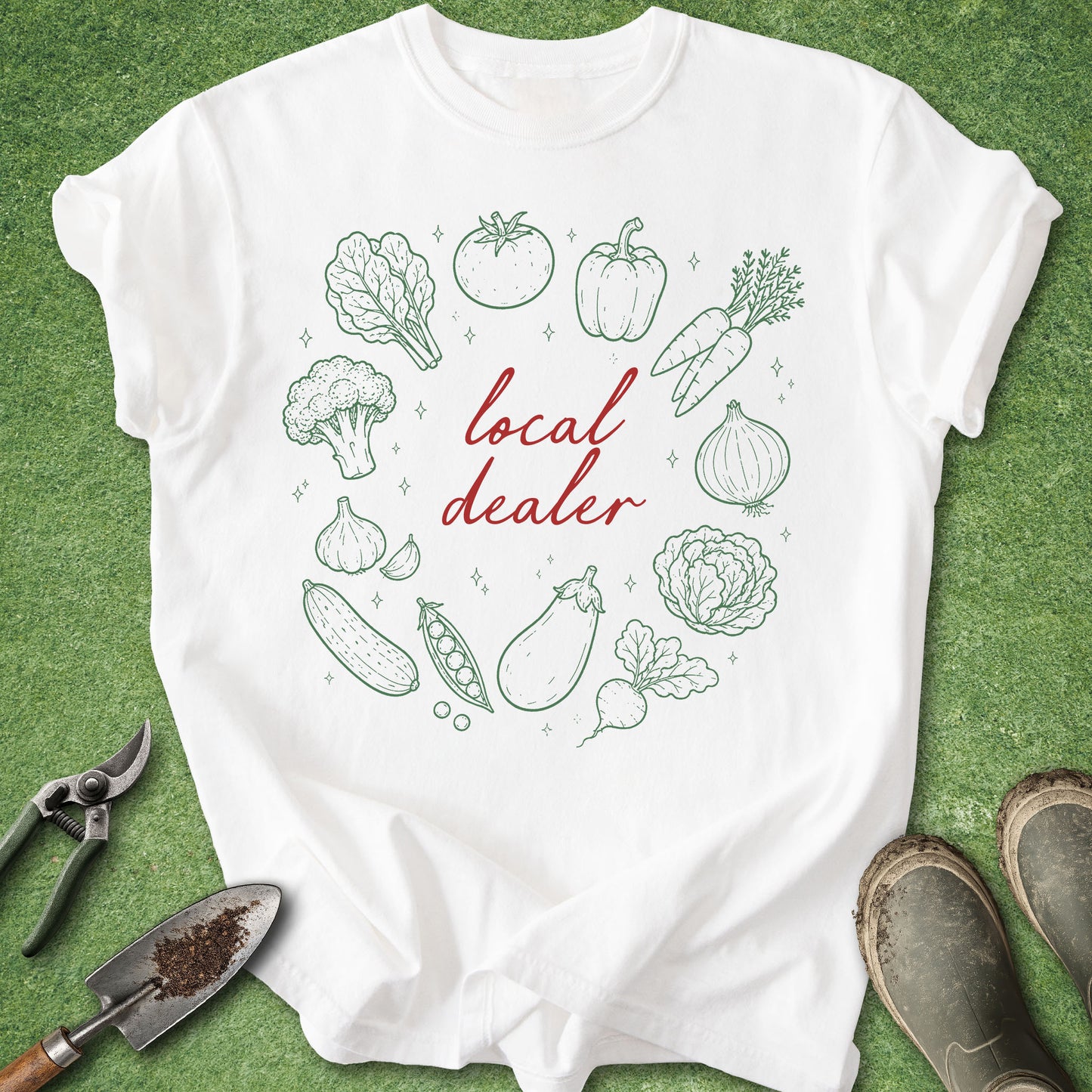 White t-shirt with green vegetable illustrations and 'local dealer' text on a green background