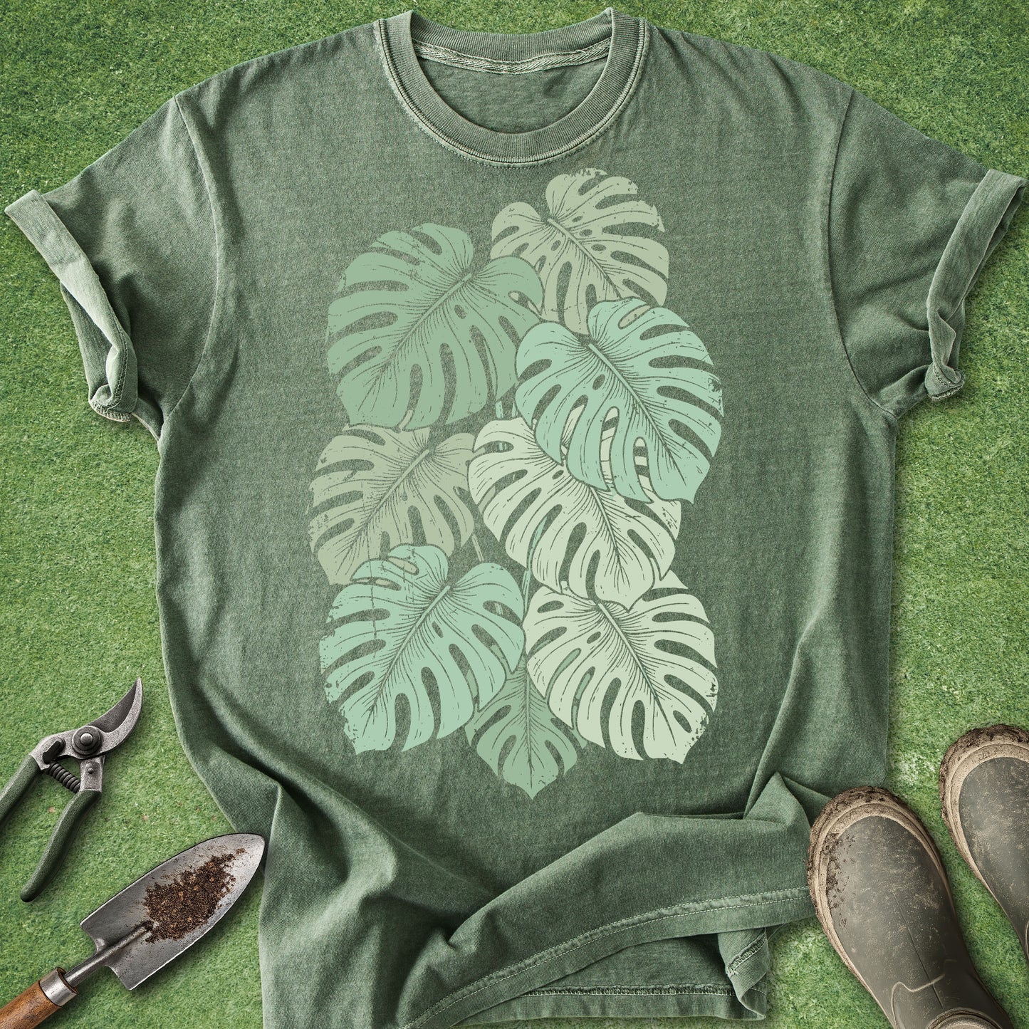 Green t-shirt with leaf design on a grassy background