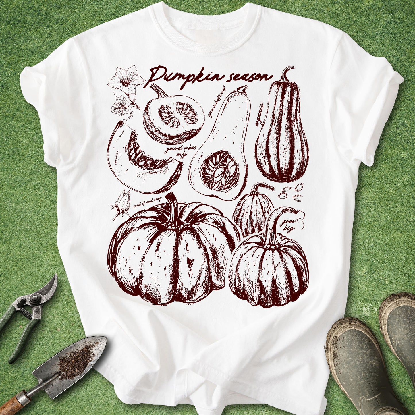 White t-shirt with pumpkin season graphic on a green background