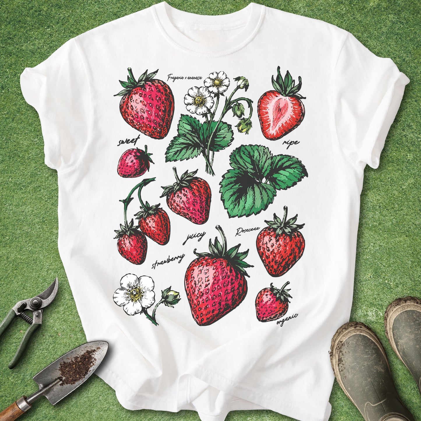 White t-shirt with strawberry design on a green grass background
