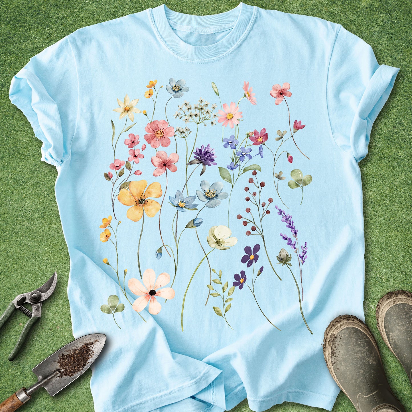 Light blue t-shirt with floral design on a green grass background