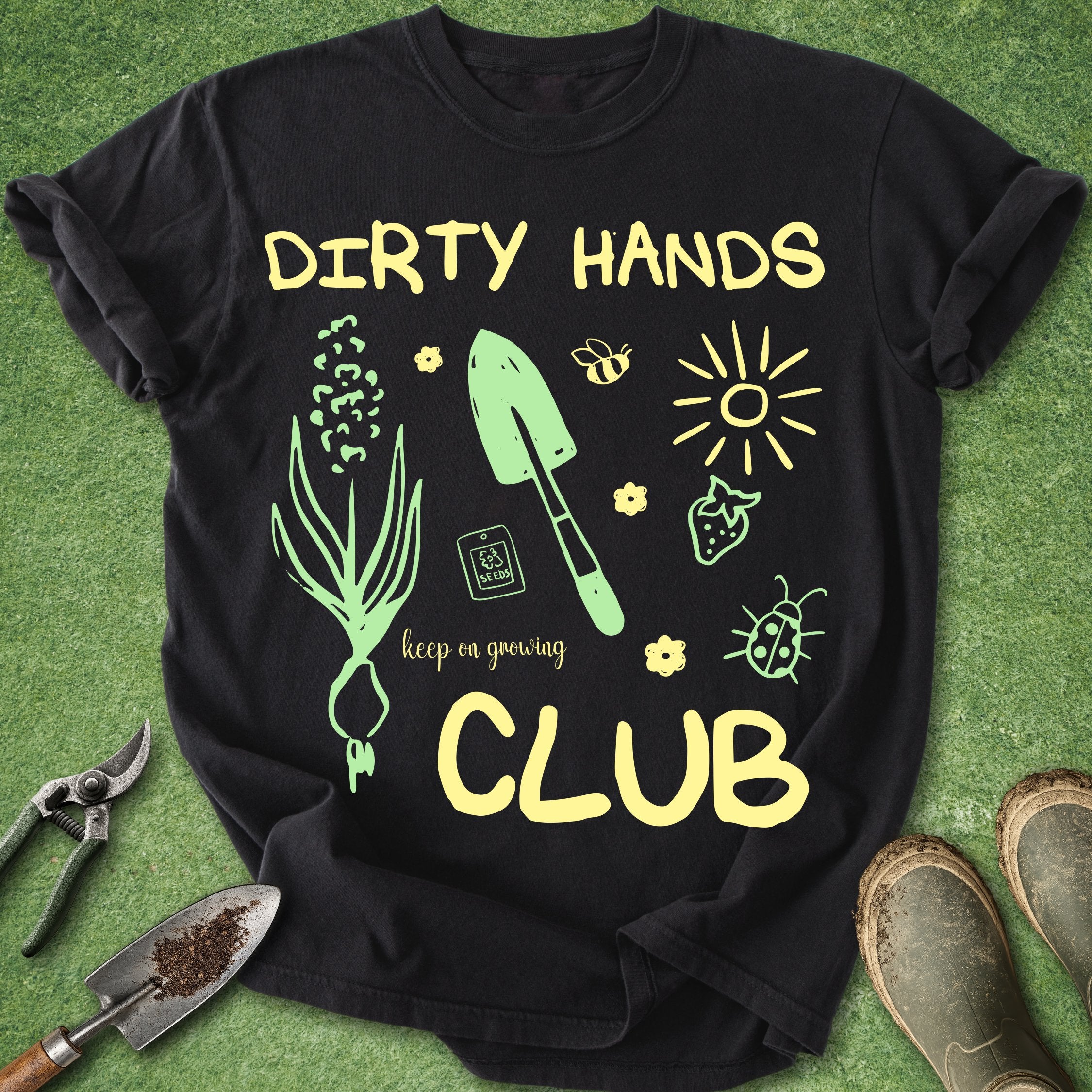 Black t-shirt with gardening-themed design and tools on a green background