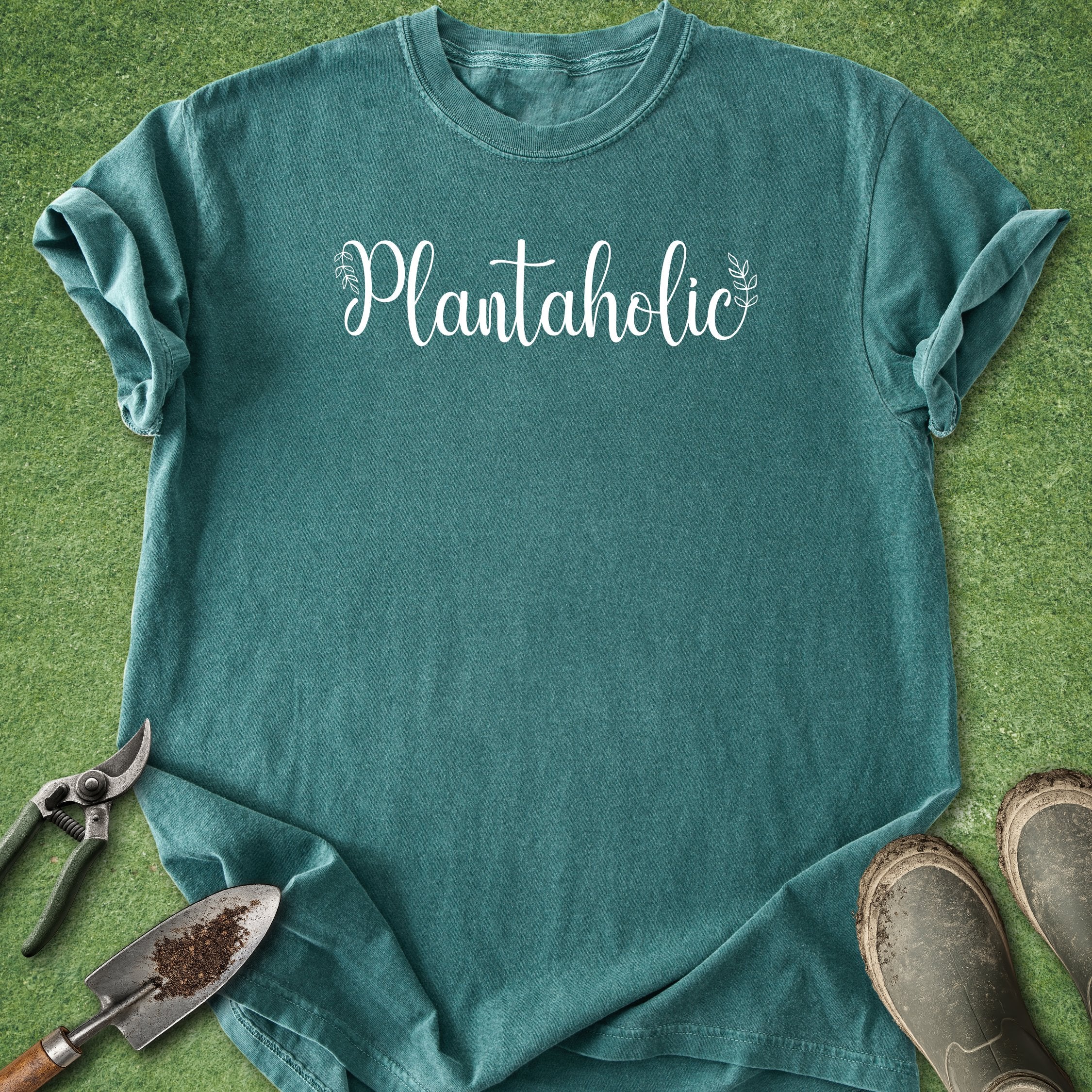 Teal t-shirt with 'Plantaholic' text on a grass background