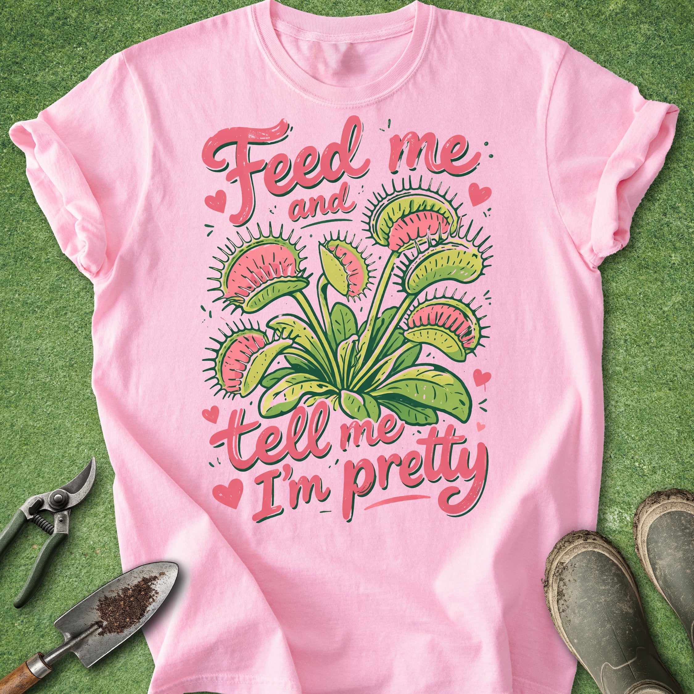 Pink t-shirt with carnivorous plant design and text on a green background