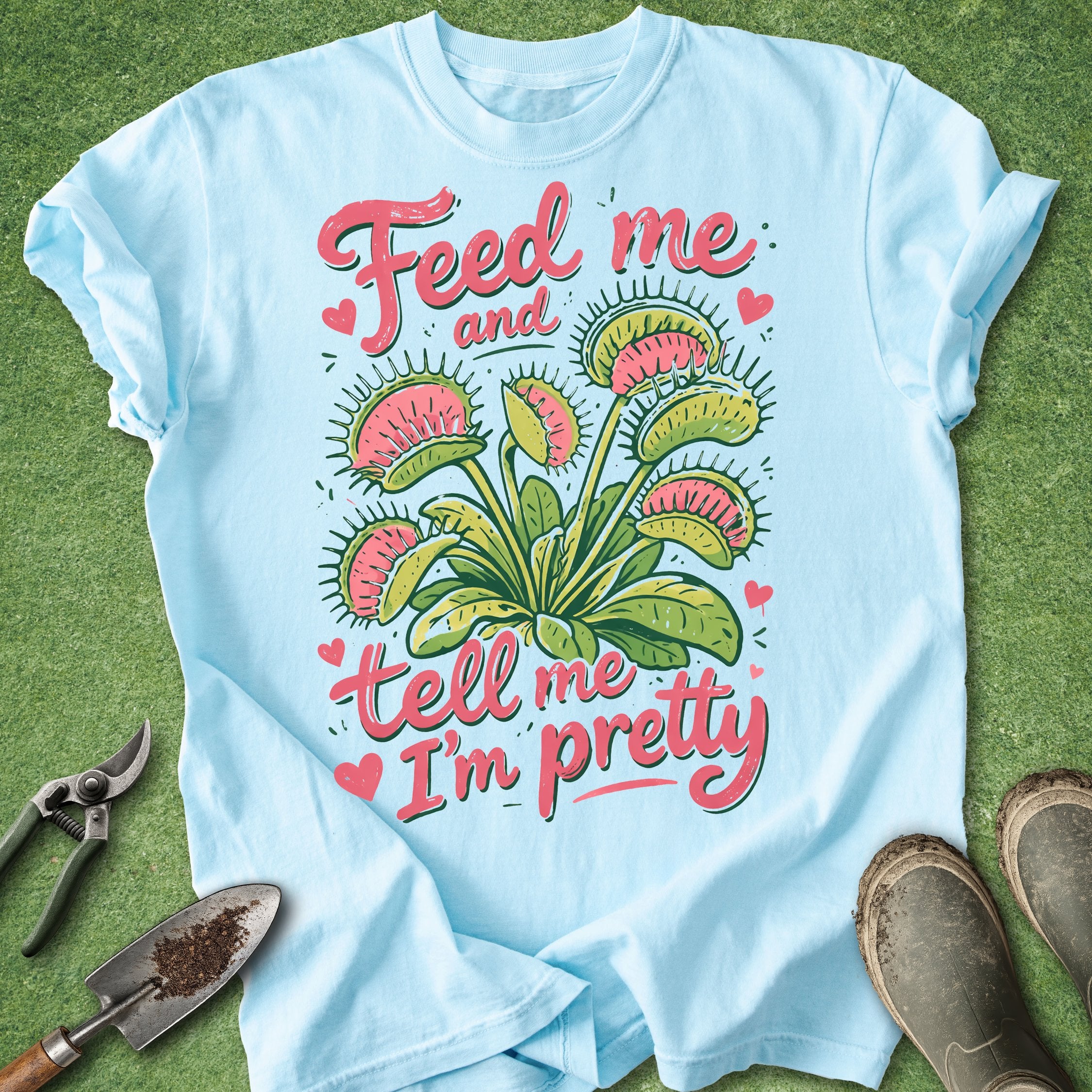Light blue t-shirt with floral design and text on a grass background
