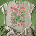 Beige t-shirt with plant graphic and text on a green background