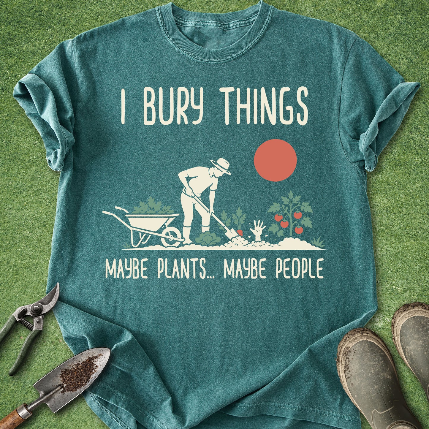 Teal t-shirt with gardening graphic and text on a grass background