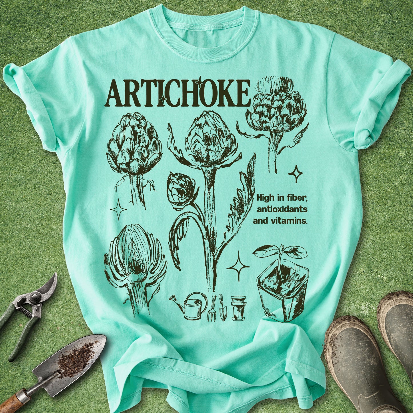 Island Reef Comfort Colors t-shirt featuring vintage botanical illustrations of artichokes in different growth stages with gardening icons and educational text in a natural history inspired design.