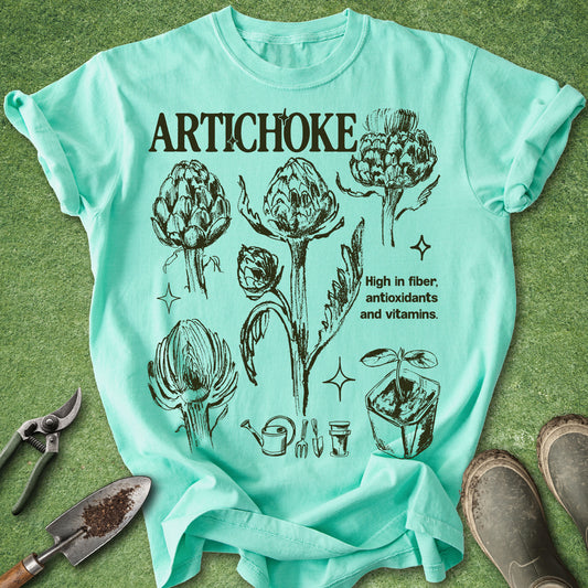 Island Reef Comfort Colors t-shirt featuring vintage botanical illustrations of artichokes in different growth stages with gardening icons and educational text in a natural history inspired design.