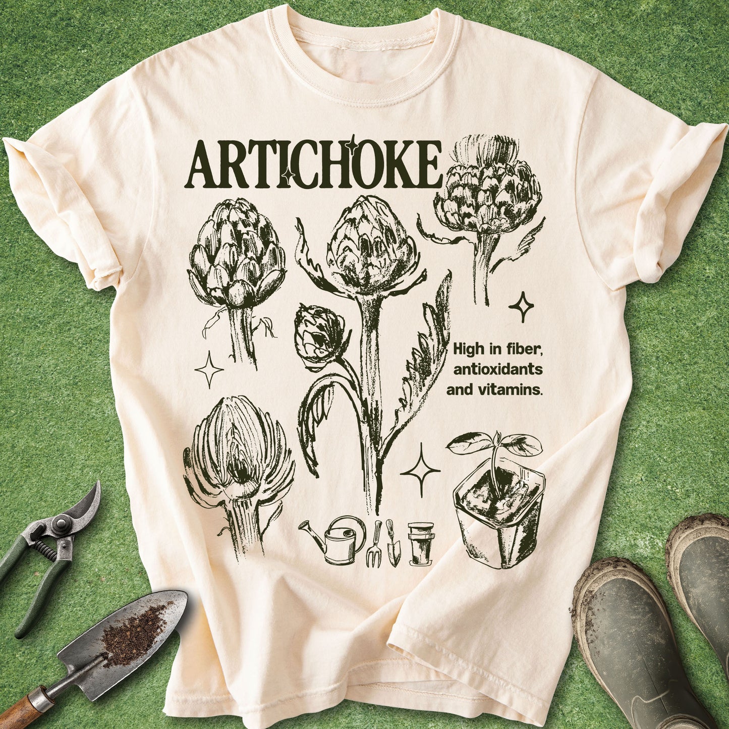 Ivory Comfort Colors t-shirt featuring vintage botanical illustrations of artichokes in different growth stages with gardening icons and educational text in a natural history inspired design.