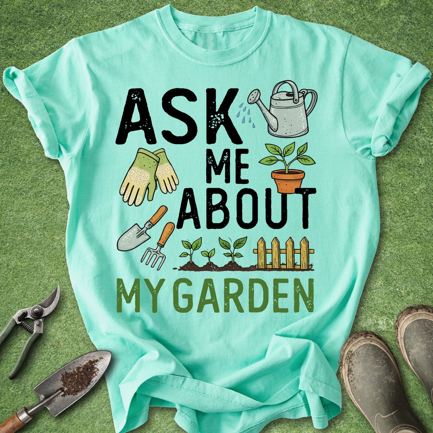 Mint green t-shirt with gardening-themed text and graphics on a grass background