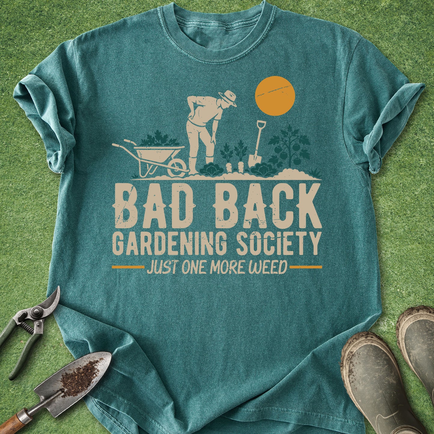 Teal t-shirt with gardening graphic and text on a grass background