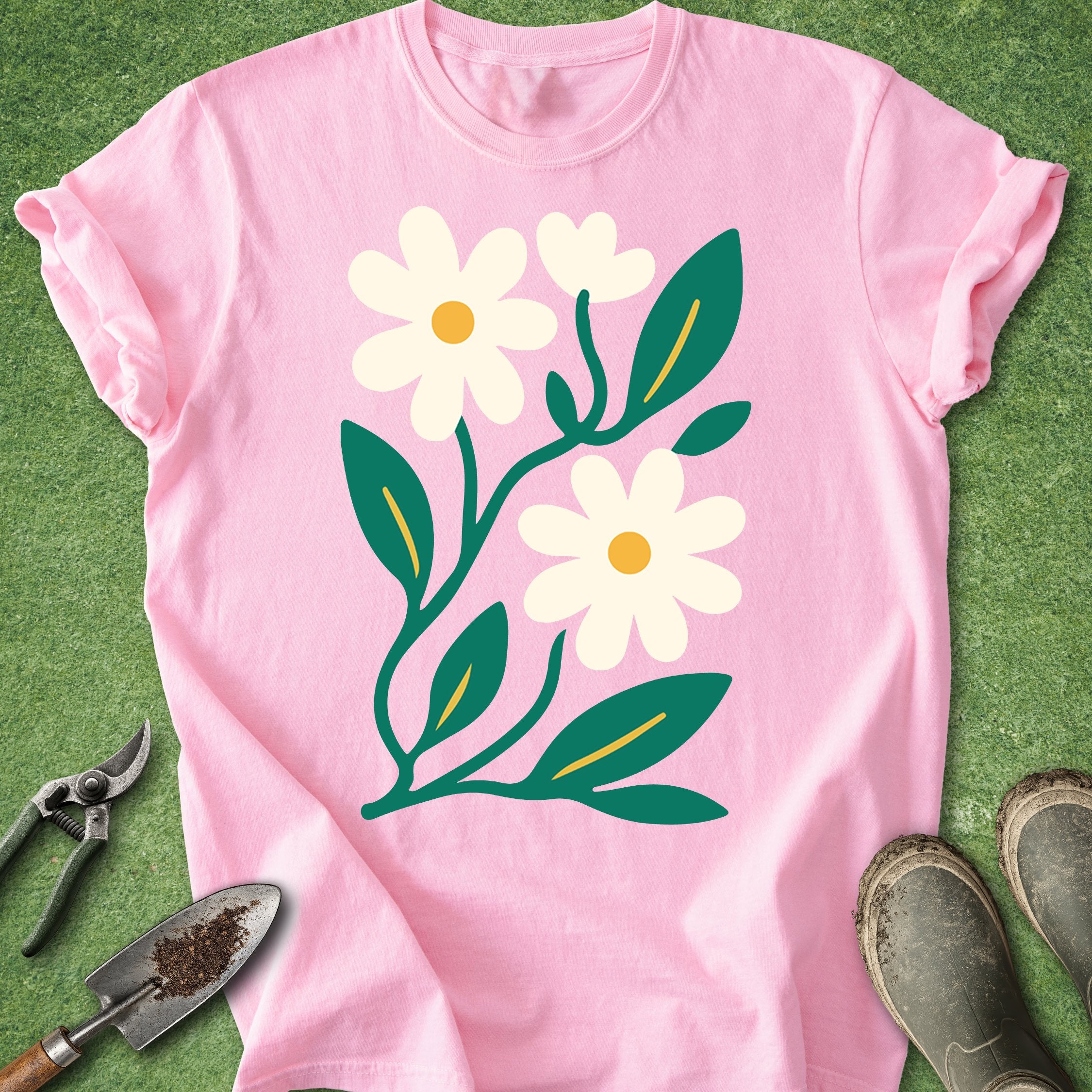 Pink t-shirt with floral design on a green grass background