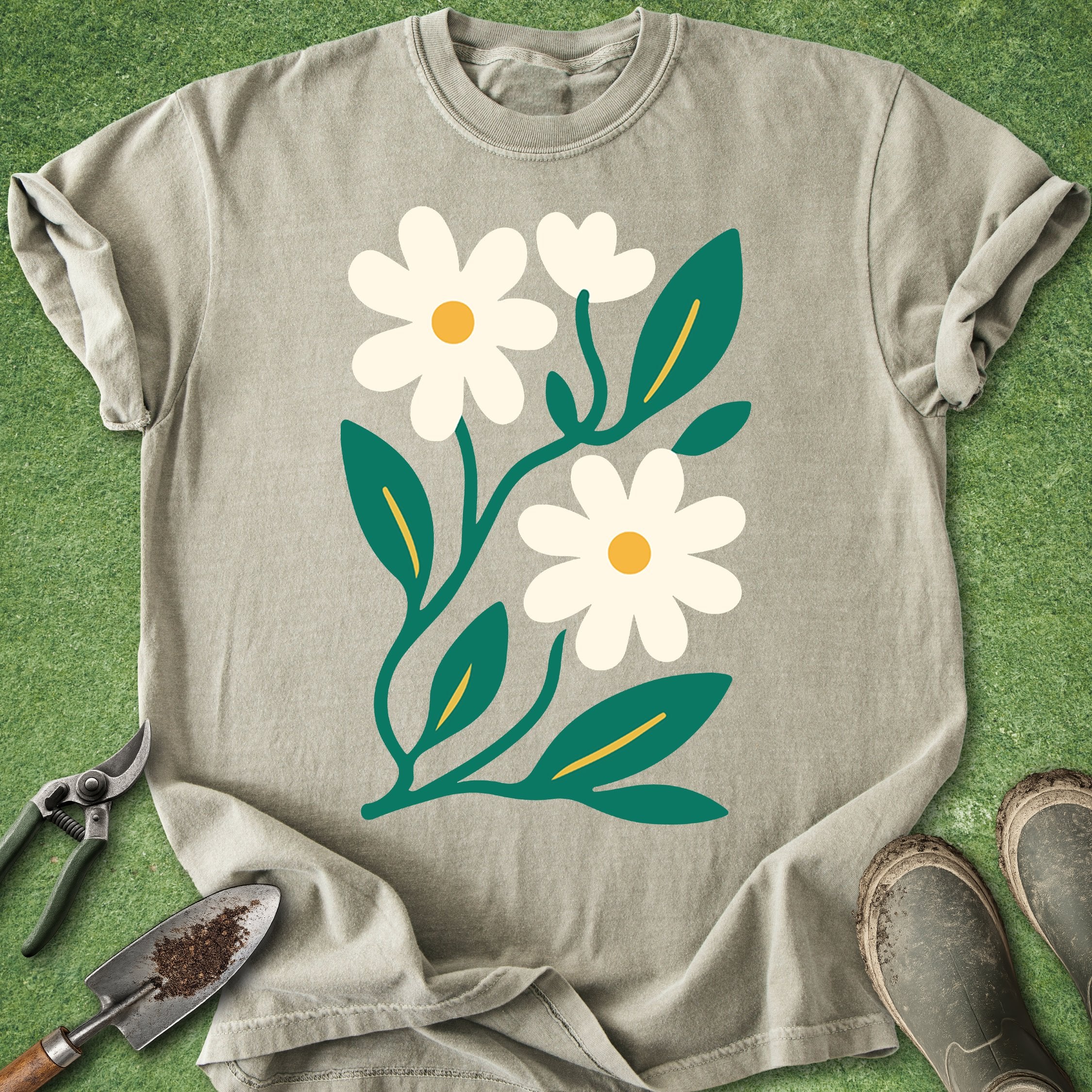 Beige t-shirt with white flowers and green leaves on a grass background