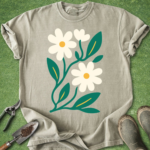 Beige t-shirt with white flowers and green leaves on a grass background