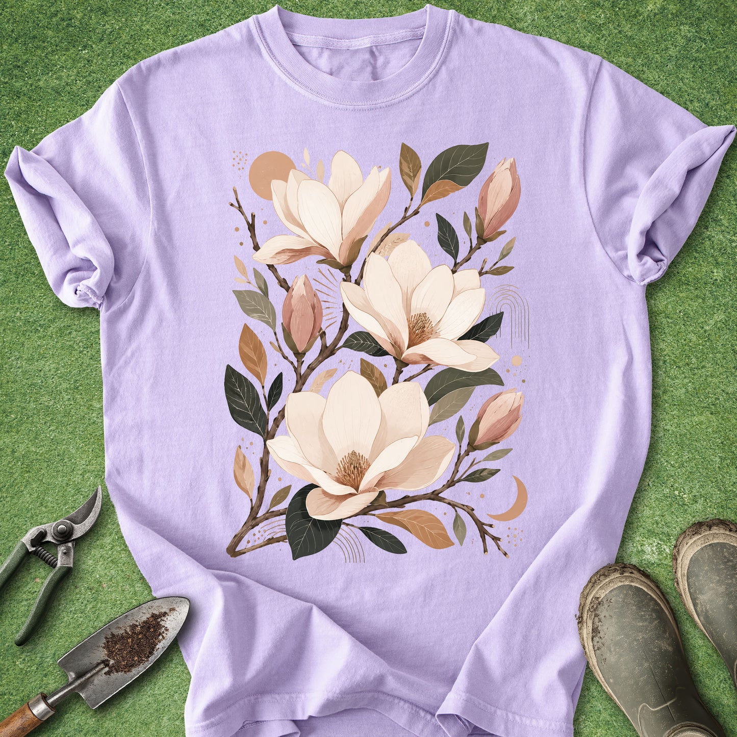 Orchid-colored t-shirt featuring a boho botanical illustration of blooming magnolia flowers with buds, branches, and warm neutral accents.