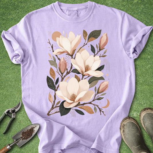 Orchid-colored t-shirt featuring a boho botanical illustration of blooming magnolia flowers with buds, branches, and warm neutral accents.