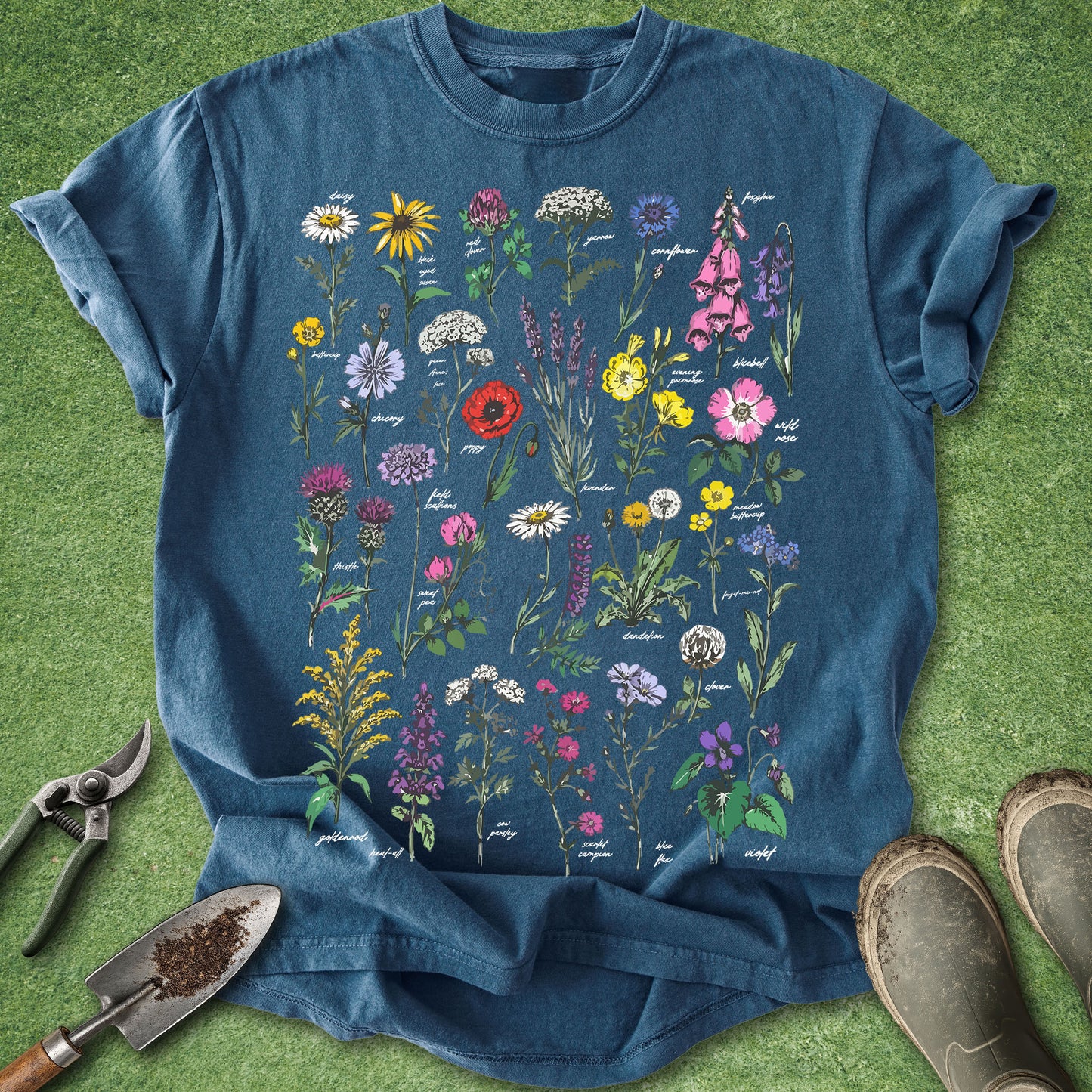 Blue t-shirt with colorful floral design on a green grass background