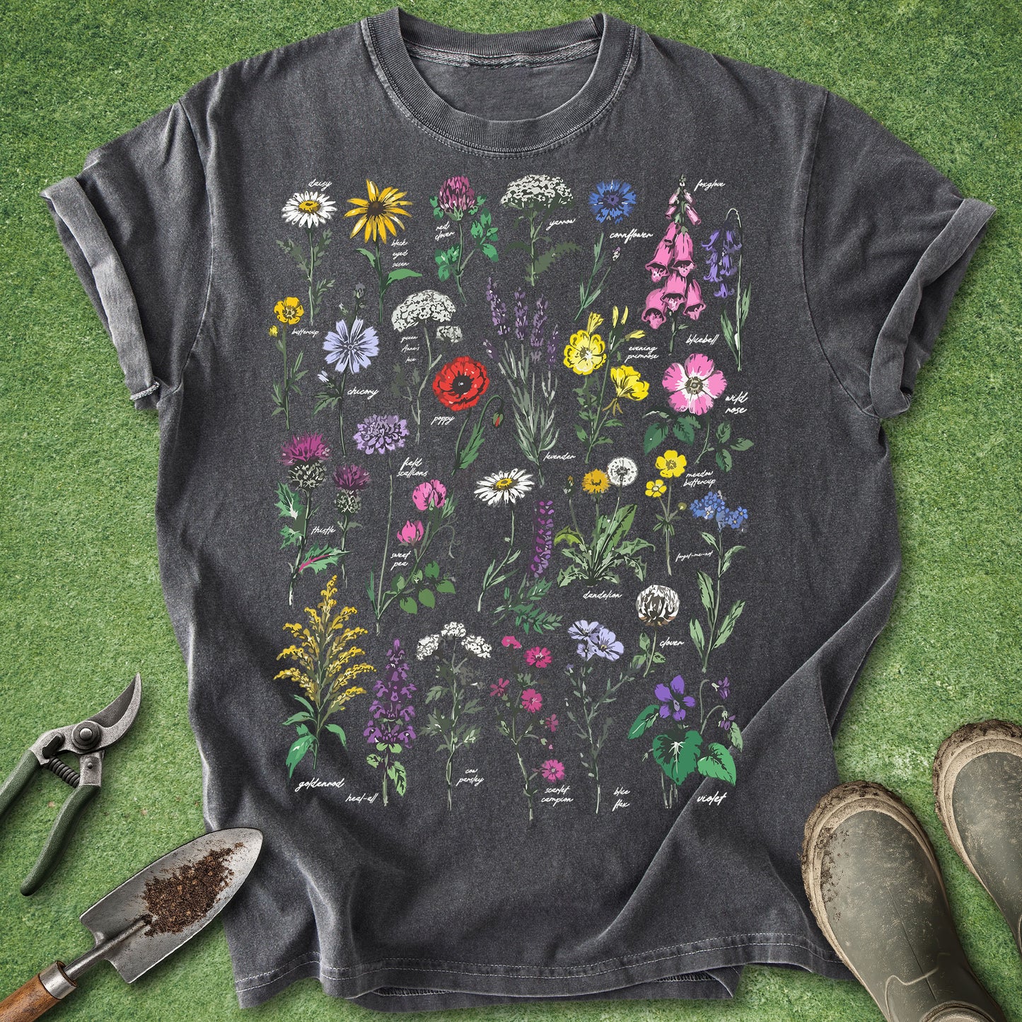 Dark gray t-shirt with colorful floral design on a green grass background