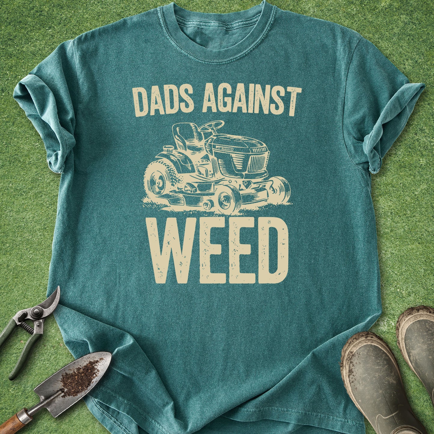 Teal t-shirt with 'Dads Against Weed' graphic on a grass background