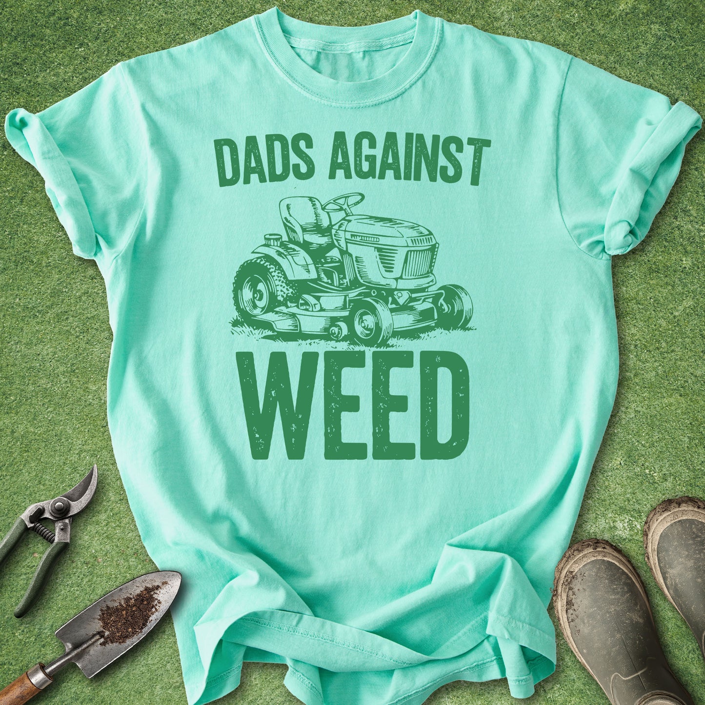 Mint green t-shirt with 'Dads Against Weed' graphic on a grass background