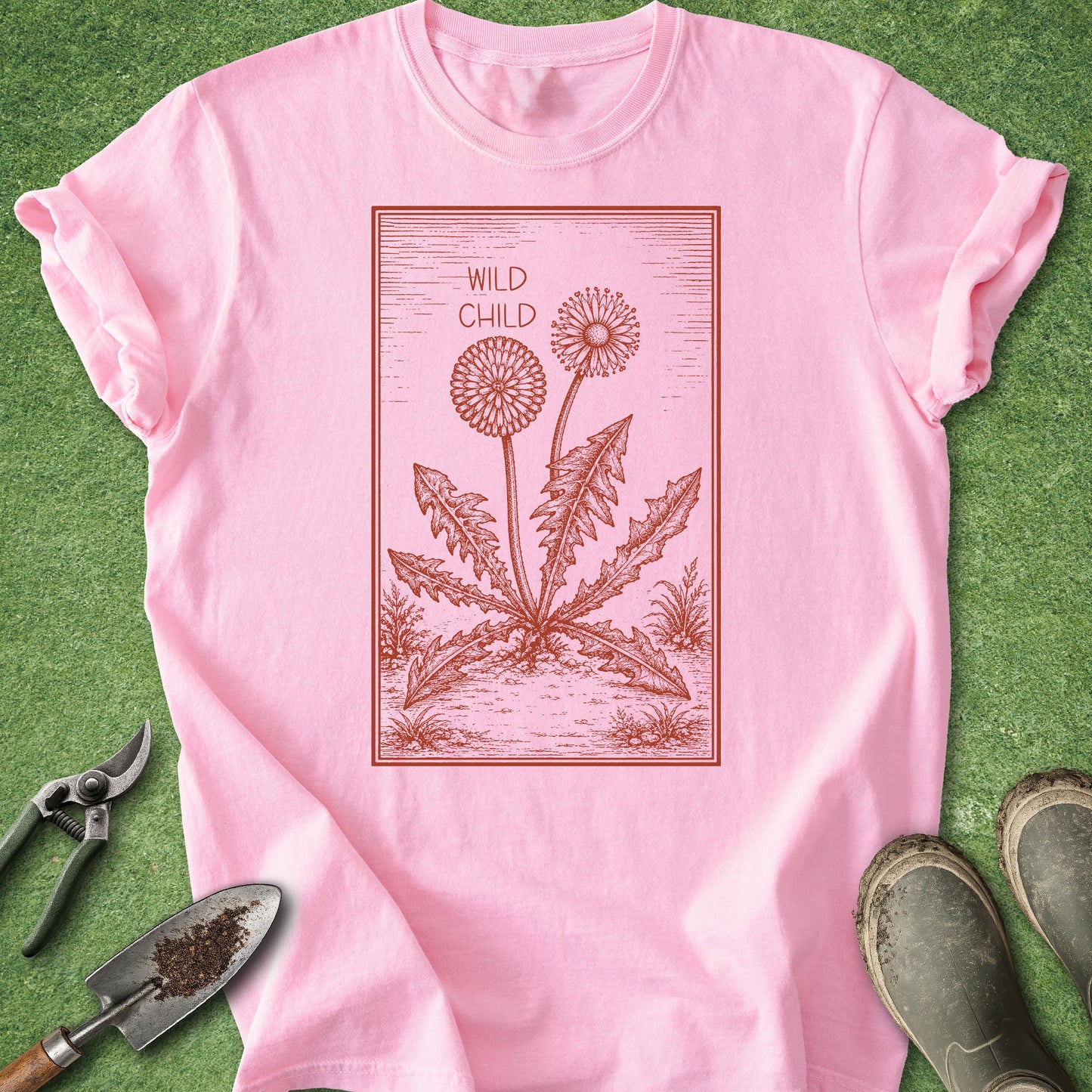 Pink t-shirt with dandelion graphic and 'Wild Child' text on a green background