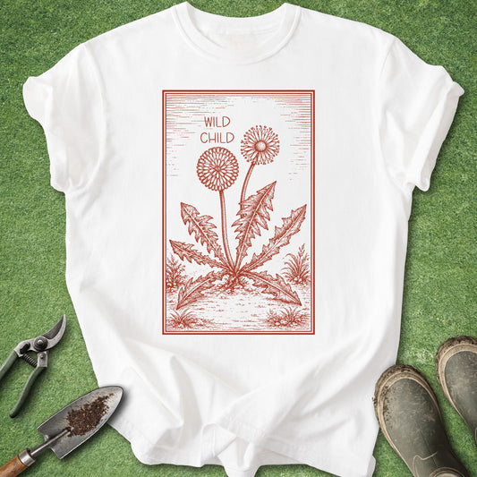 White t-shirt with red dandelion graphic and 'Wild Child' text on a green grass background.