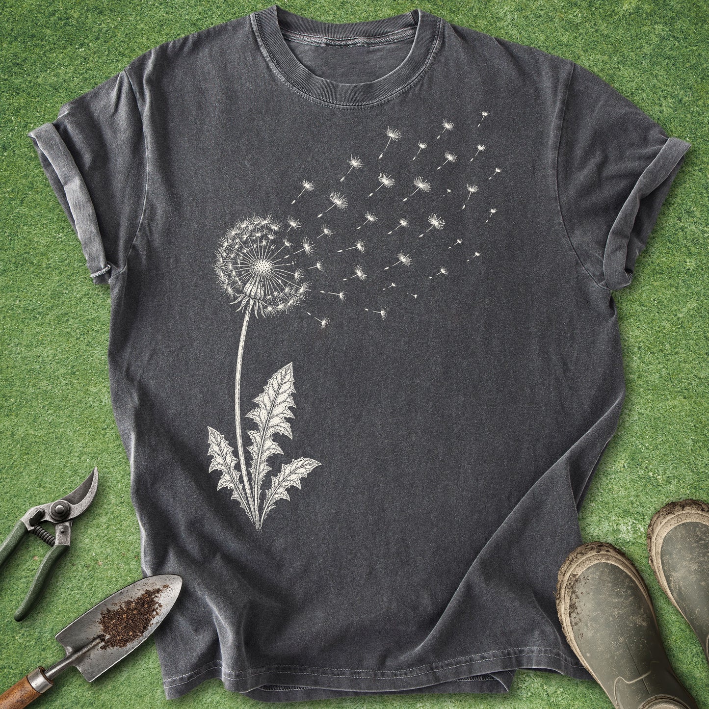 Dark gray t-shirt with dandelion graphic on a green grass background