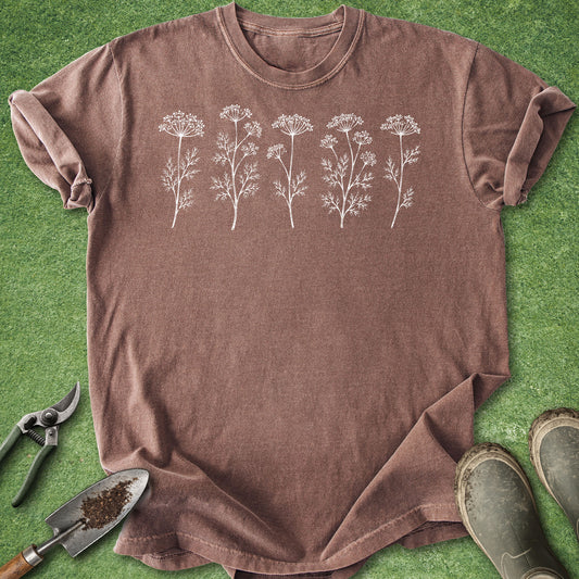 Brown t-shirt with white floral designs on a green grass background