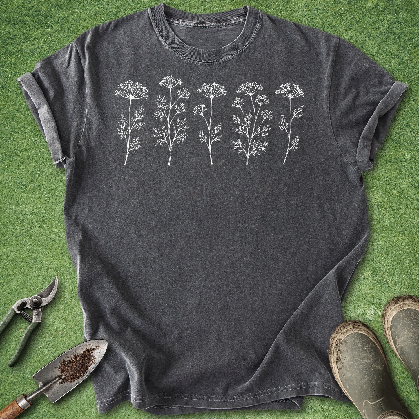 Dark gray t-shirt with white floral designs on a green grass background