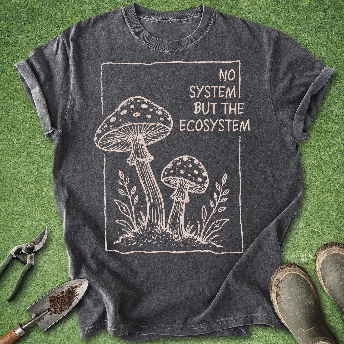Pepper Comfort Colors t-shirt featuring the phrase "No System But The Ecosystem" with a vintage illustration of two woodland mushrooms framed by simple botanical elements.