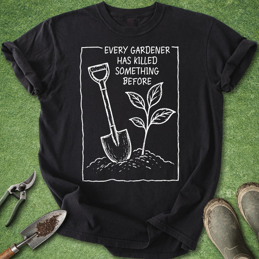 Black t-shirt with gardening graphic and text on a green grass background