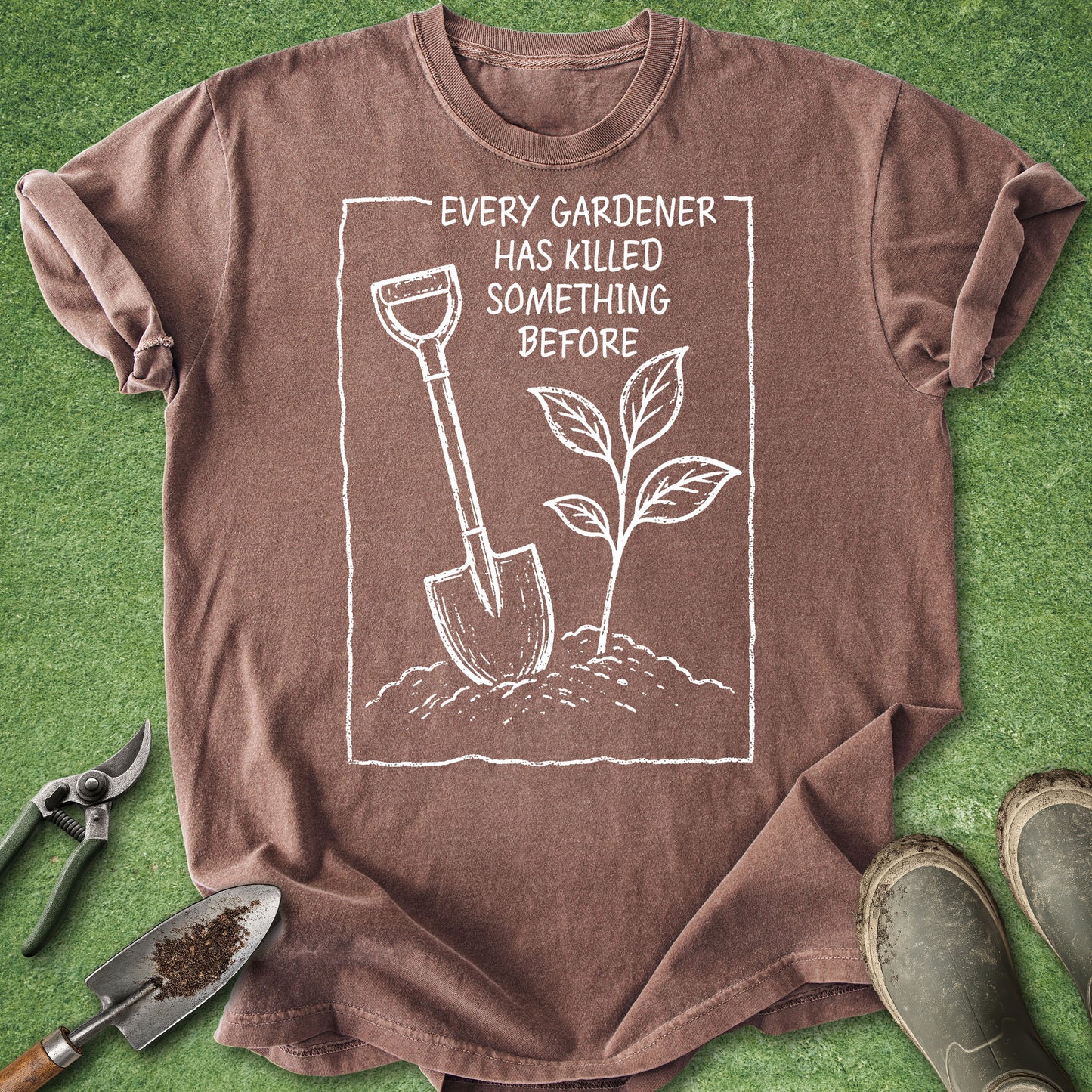Brown t-shirt with gardening graphic and text on a green grass background