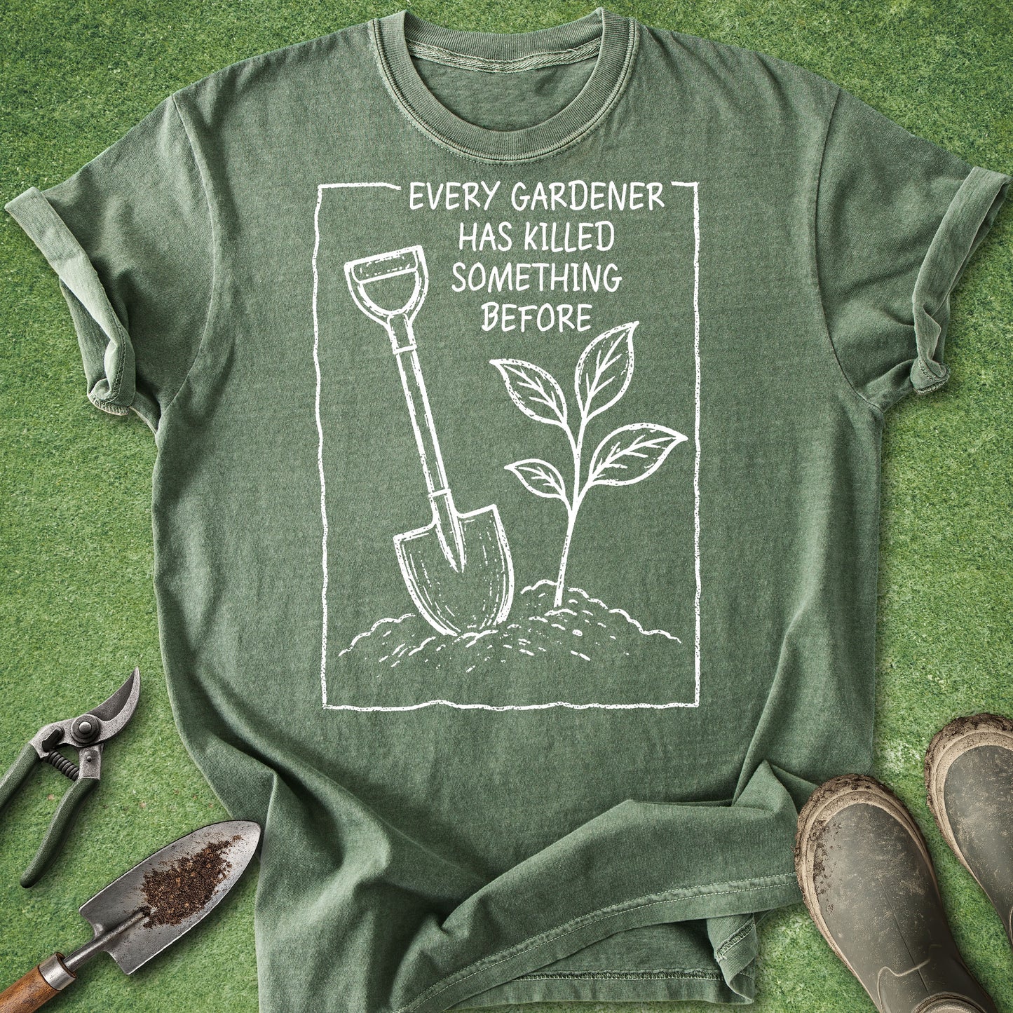 Green t-shirt with gardening graphic and text on a grass background