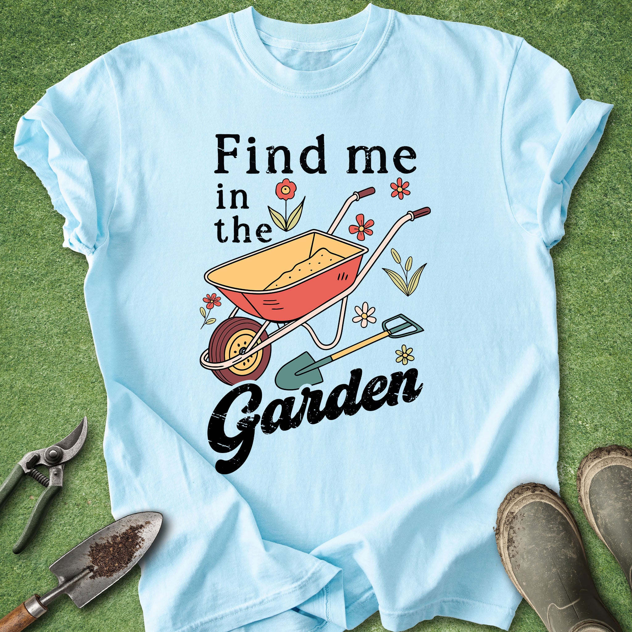 Light blue t-shirt with gardening-themed design and text on a grass background