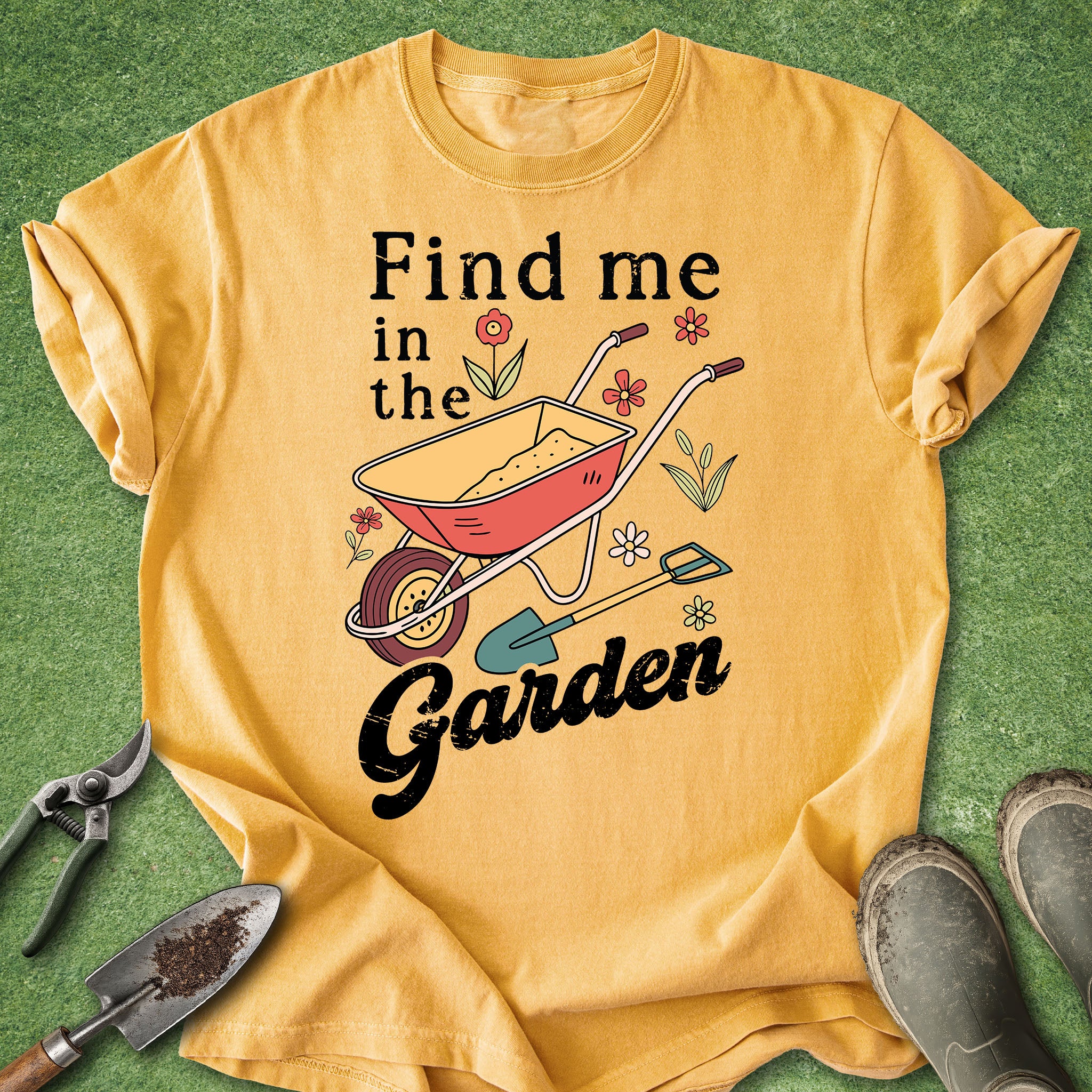 yellow t-shirt with “Find me in the garden” text and illustration of a wheelbarrow, flowers, and gardening tools
