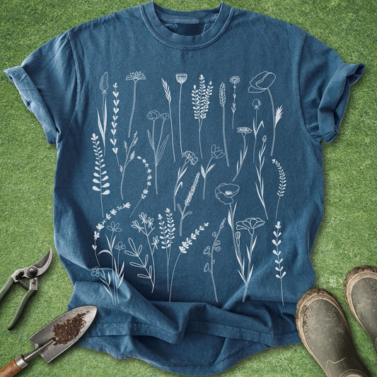 Blue t-shirt with white floral design on a green grass background