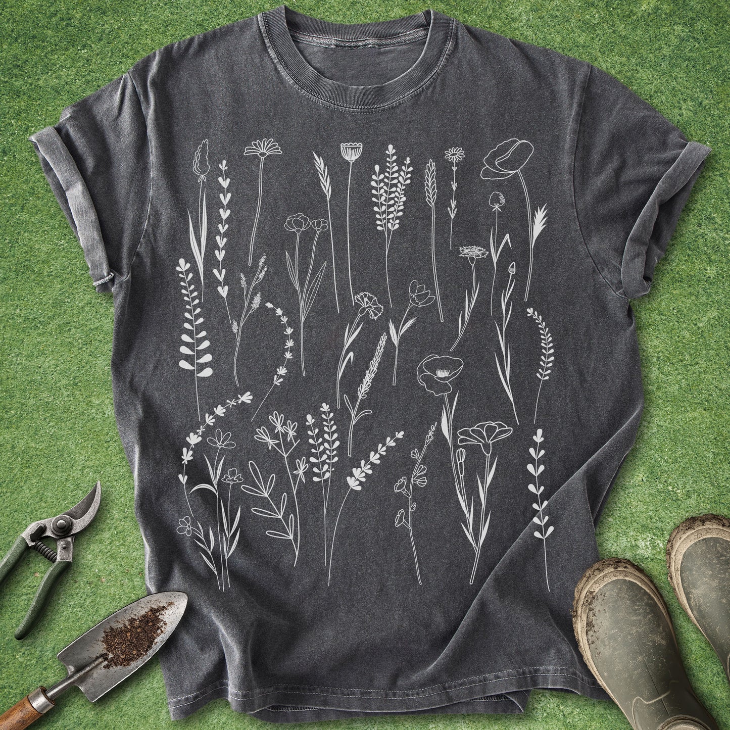Dark gray t-shirt with white floral design on a green grass background