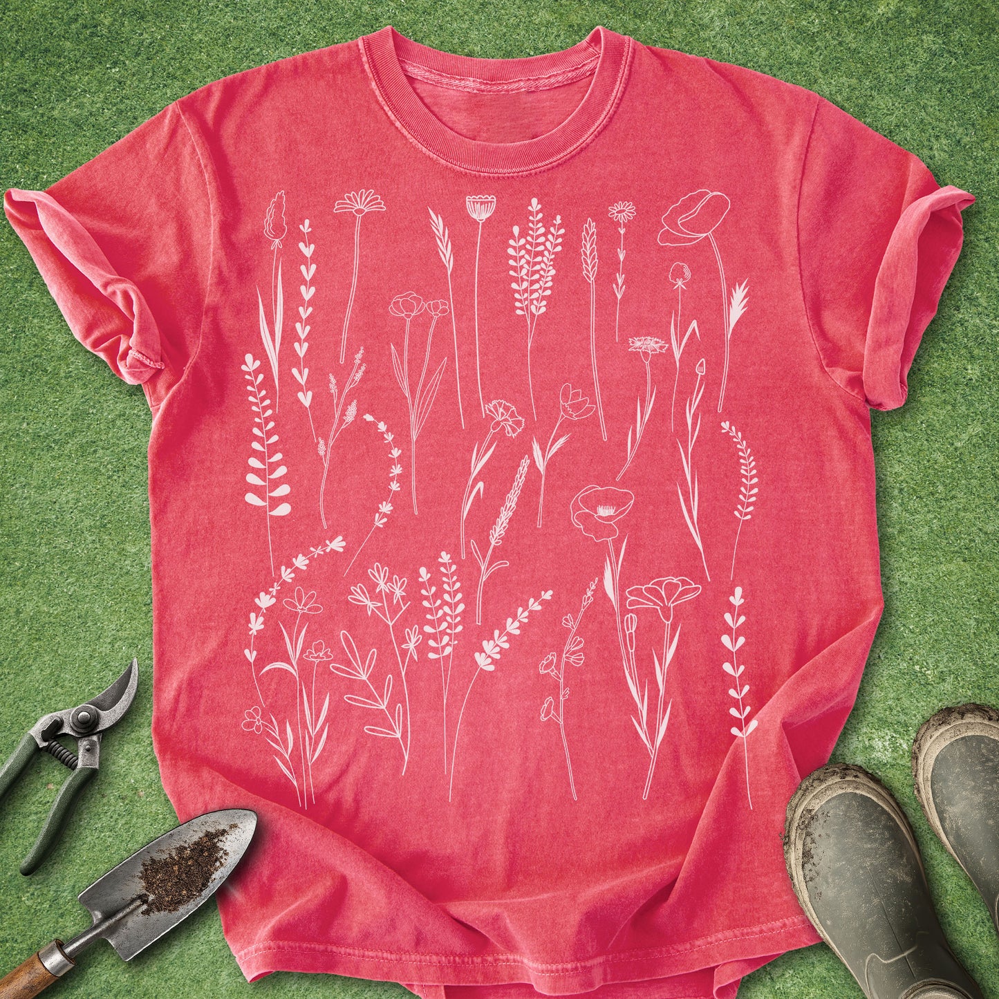 Red t-shirt with white floral patterns on a green grass background