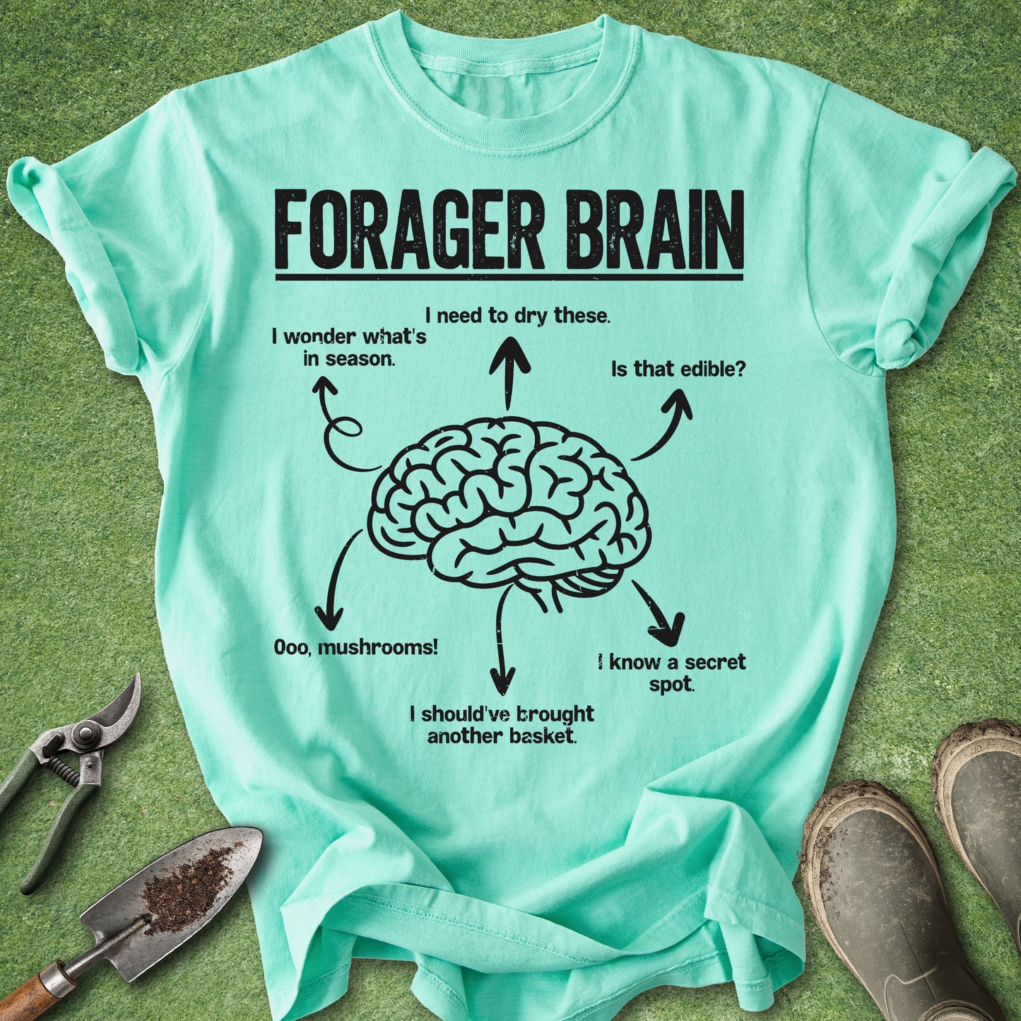 Mint green t-shirt with 'Forager Brain' graphic on a grass background