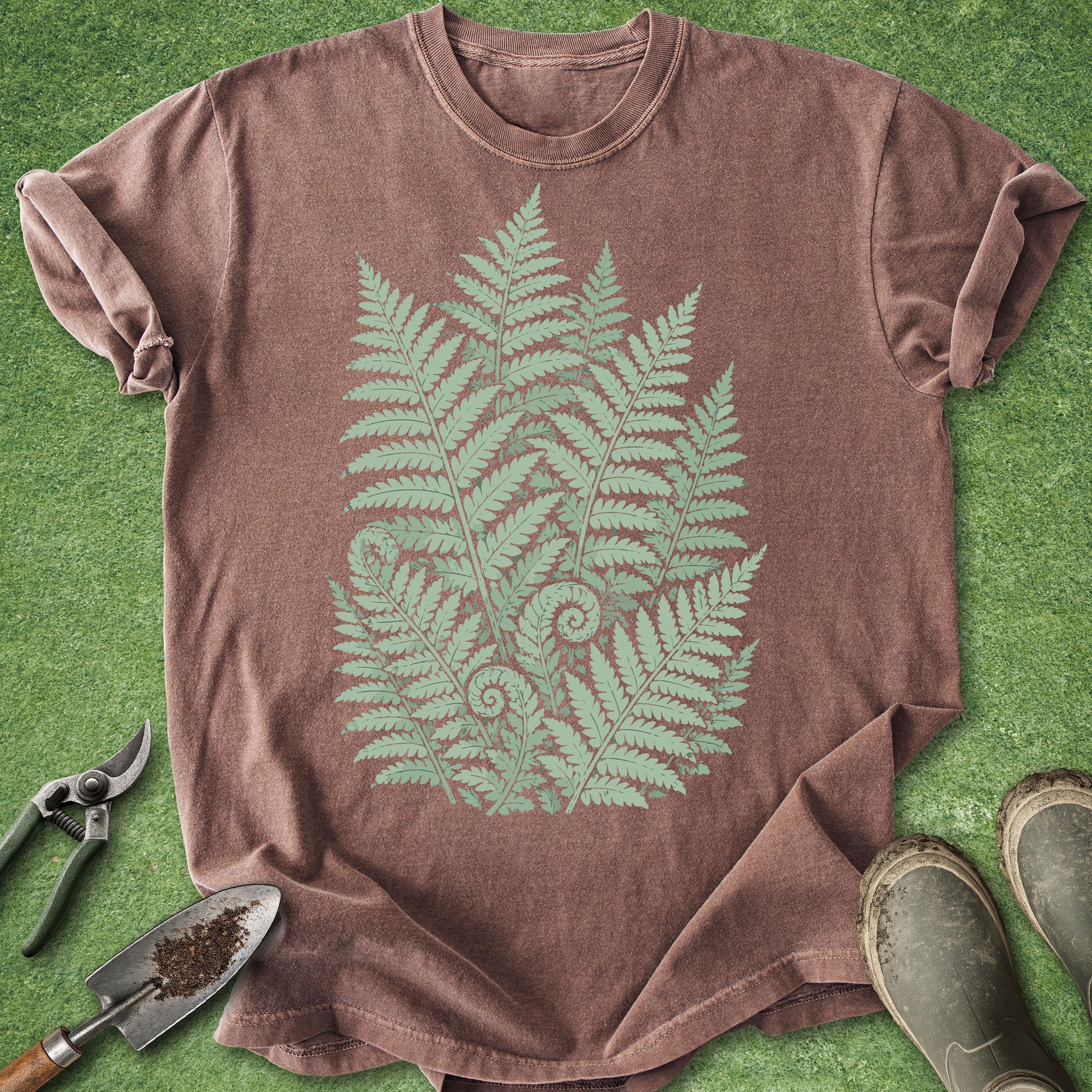 Brown t-shirt with green fern design on a grass background