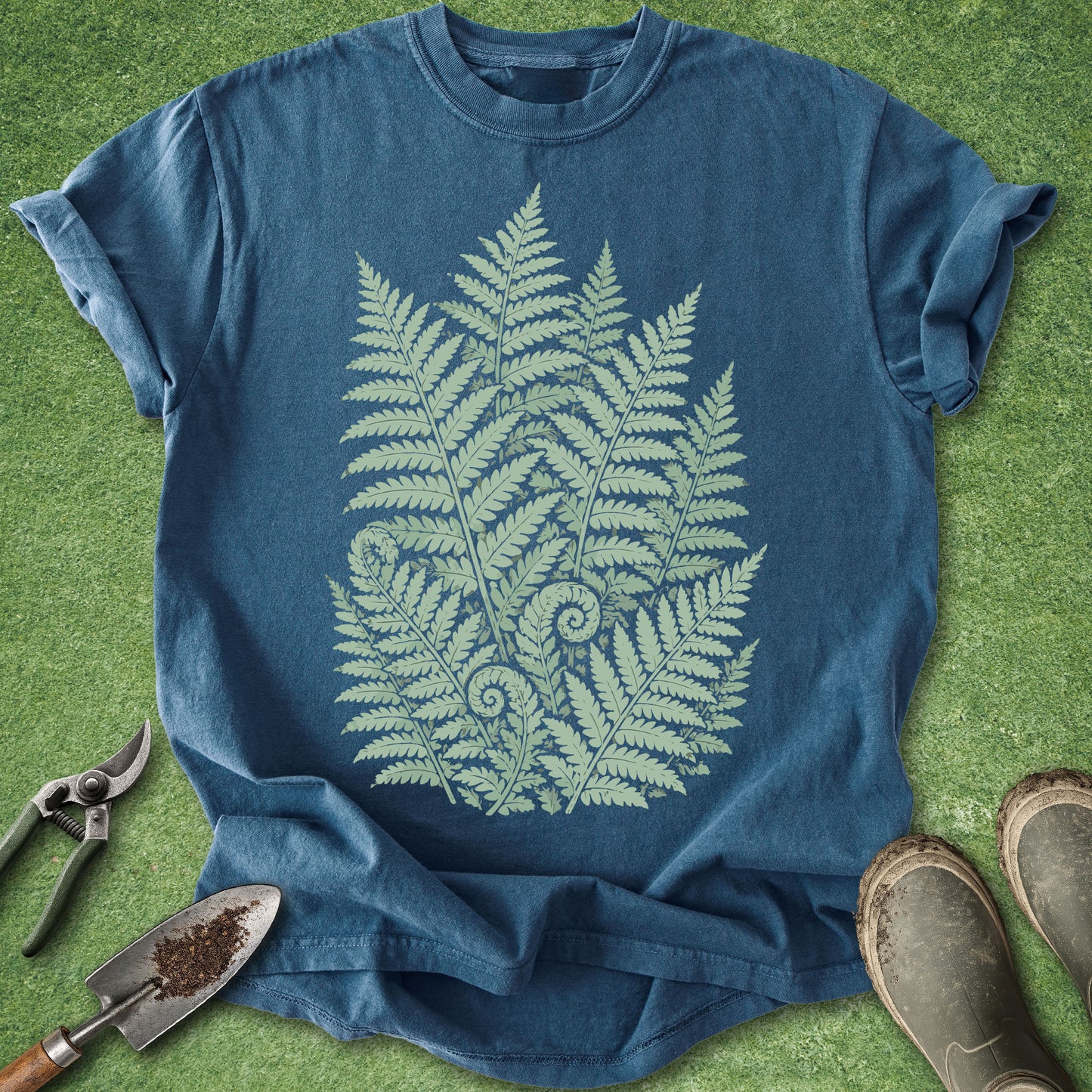 Blue t-shirt with fern design on a green grass background