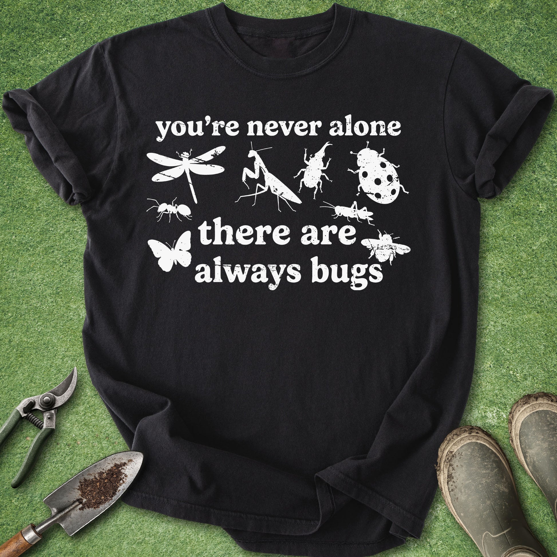 Black t-shirt with insect illustrations and text on a green grass background