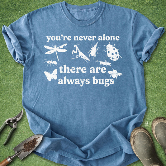 Blue t-shirt with white text and insect illustrations on a green grass background
