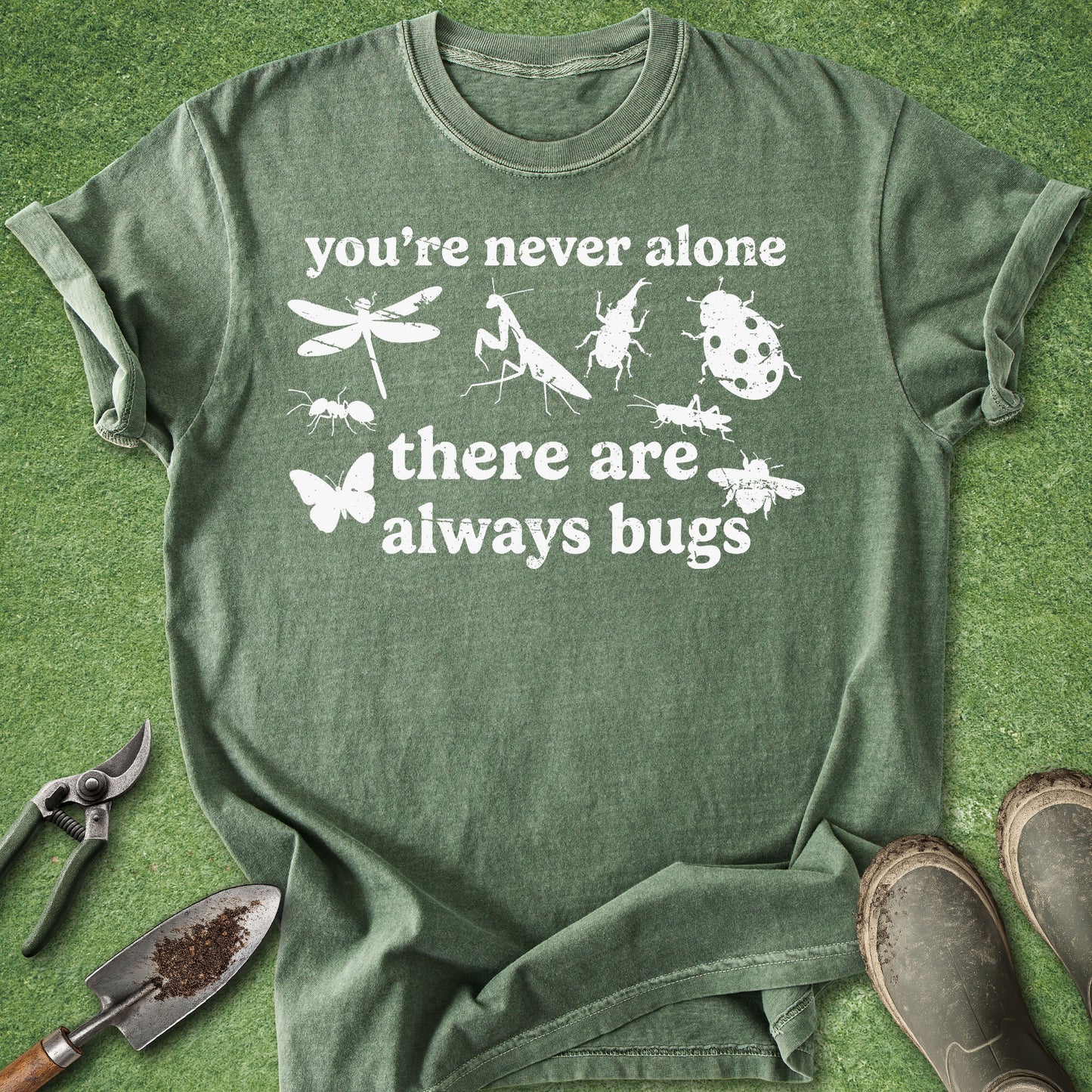 Green t-shirt with insect illustrations and text on a grassy background